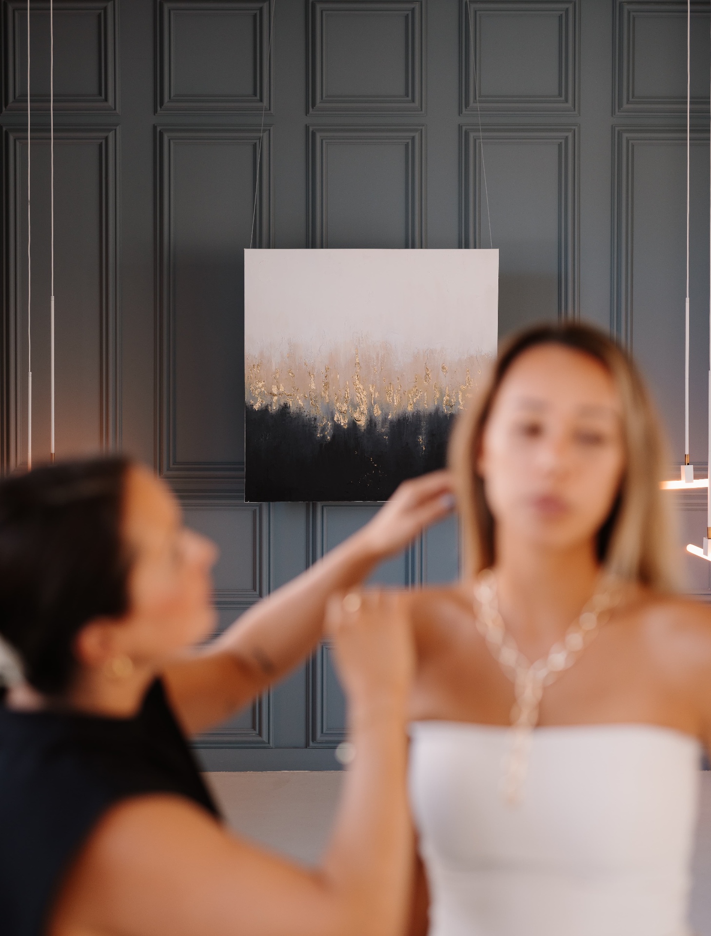 Michelle Daisy in atelier-setting met een schilderij op de achtergrond.
